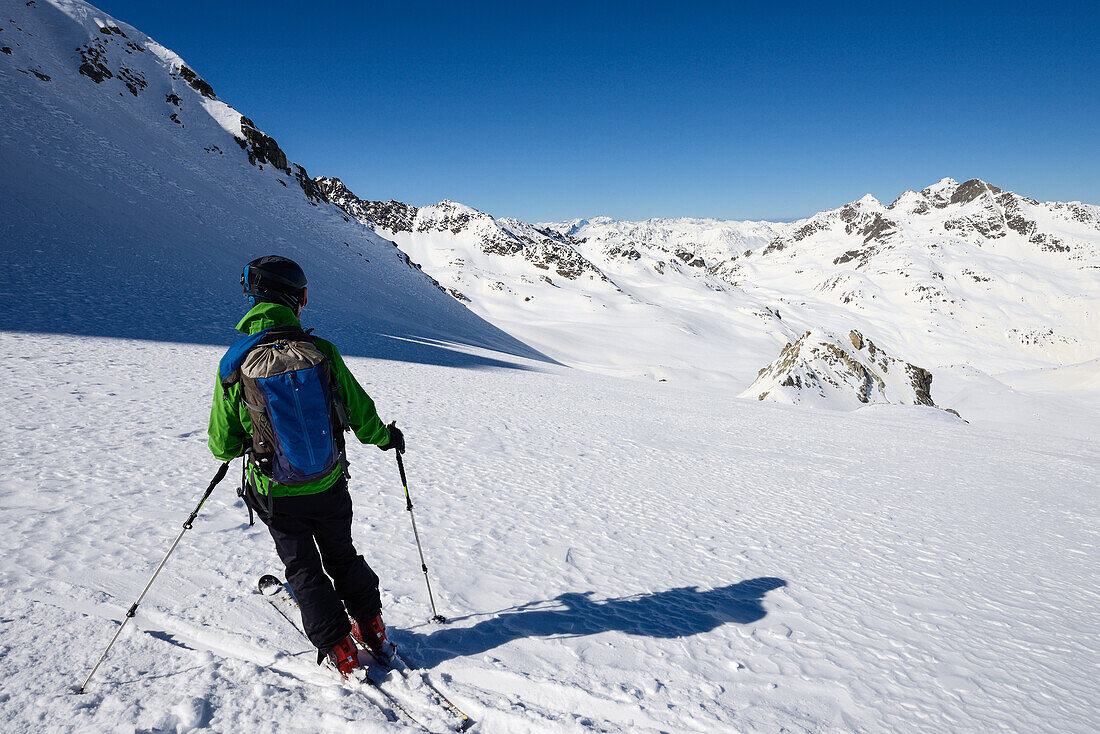 Skifahrer auf dem unverspurten Grialetsch-Gletscher (Vadret da Grialetsch) mit Isla Pers, im rechten oberen Bilddrittel die Grialetschhütte, darüber Piz Radönt und Schwarzhorn, Engadin, Schweiz, Europa
