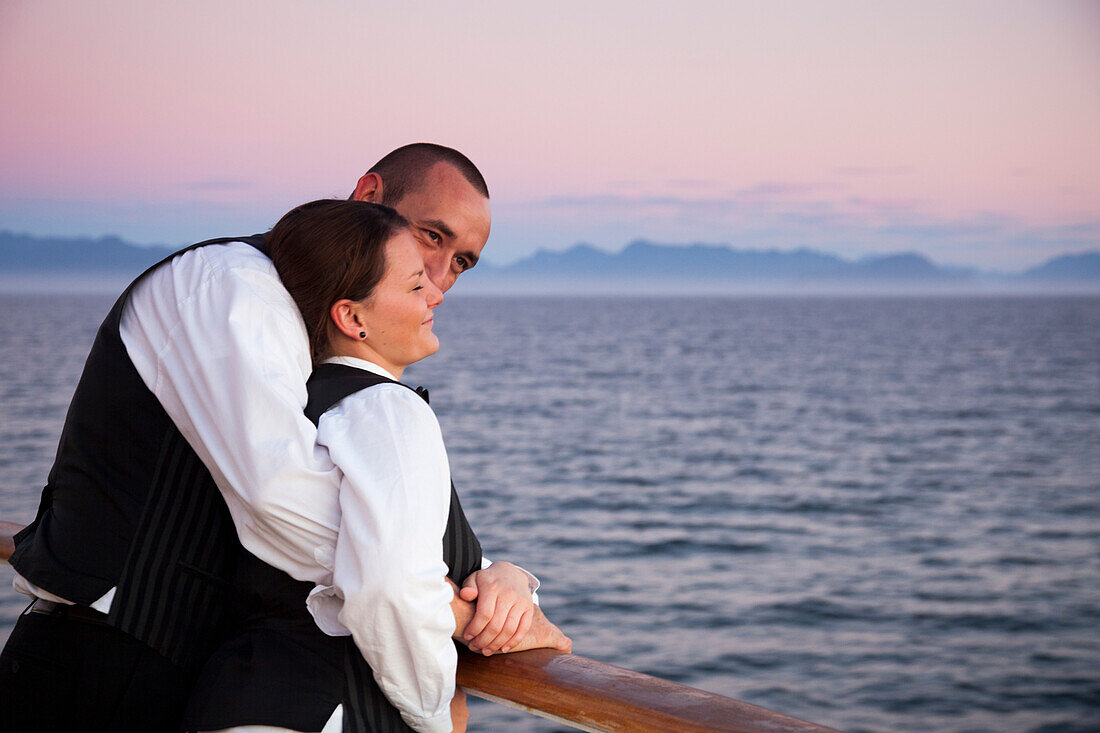 Couple enjoy sunset from railing of cruise ship MS Deutschland (Reederei Peter Deilmann), Chilean fjords, Magallanes y de la Antartica Chilena, Patagonia, Chile