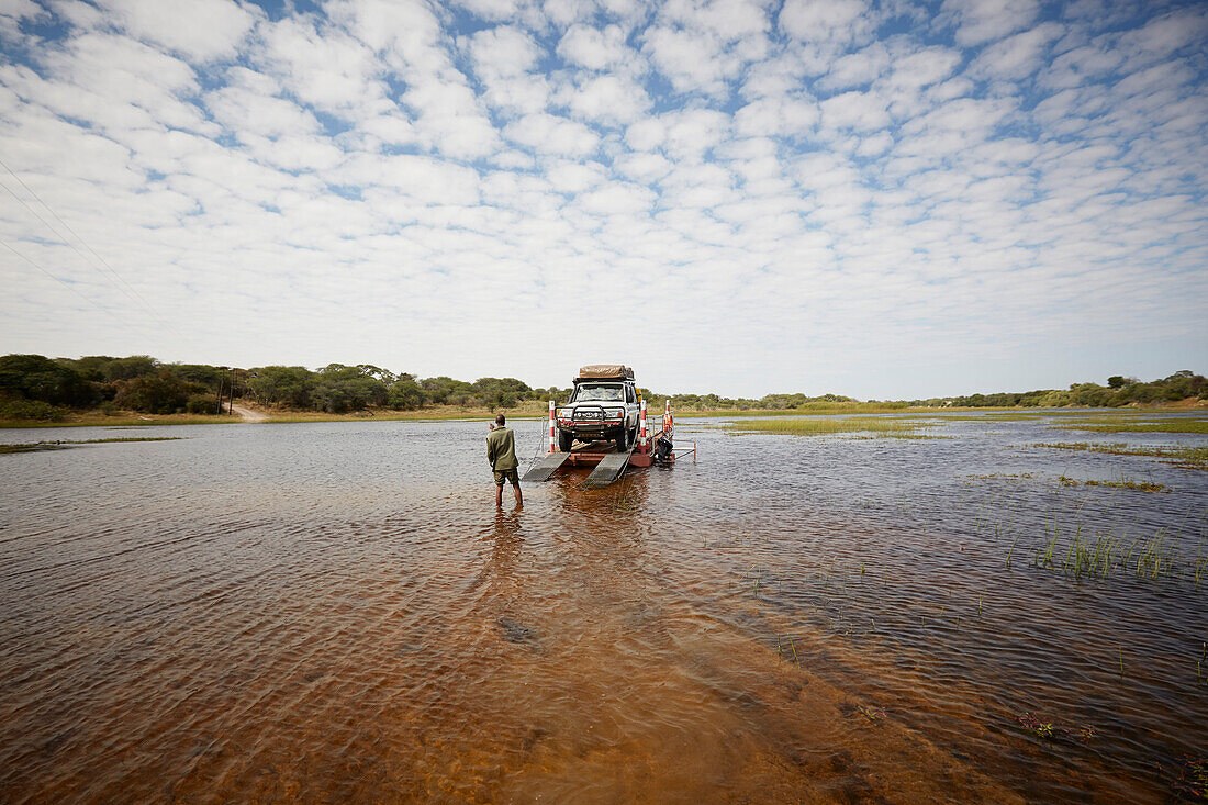 Geländewagen auf einer Fähre überquert Boteti, Makgadikgadi-Pans-Nationalpark, Botswana