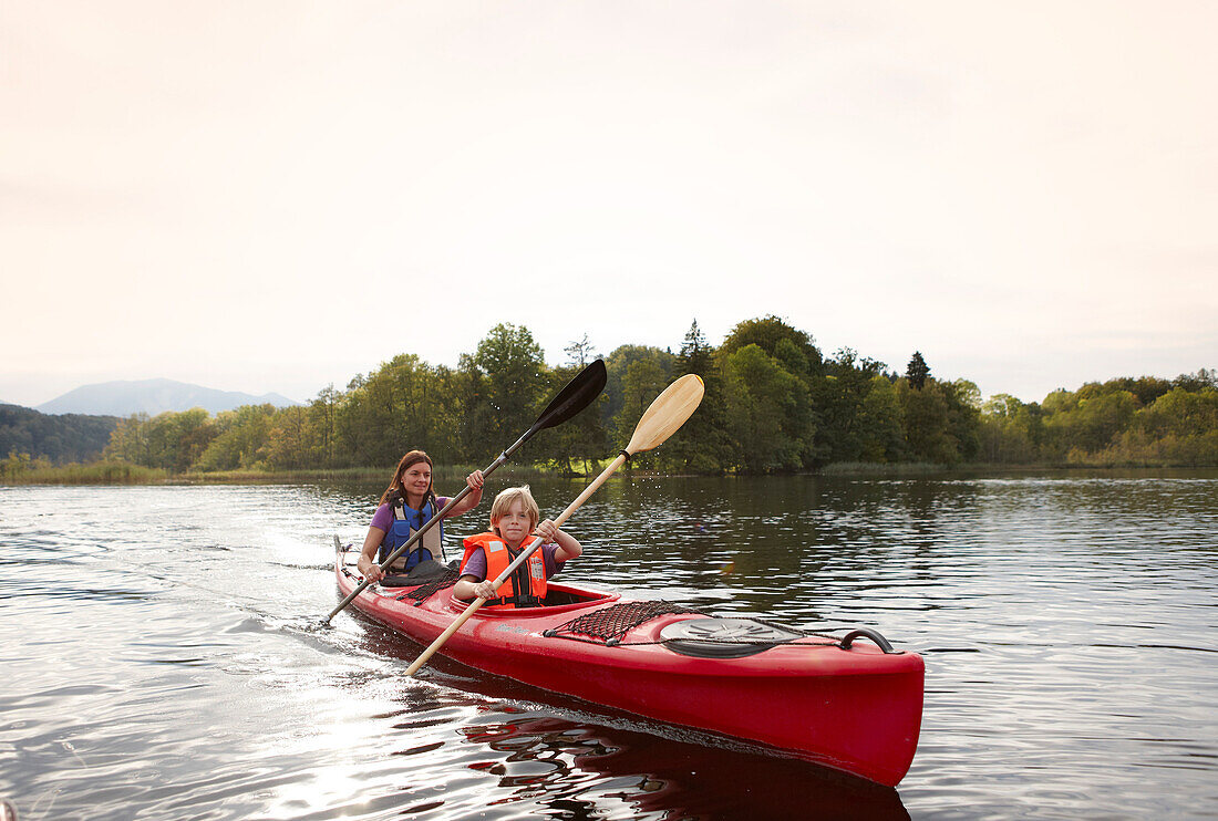 Mother and son canoe touring on lake Staffelsee, Seehausen, Upper Bavaria, Germany