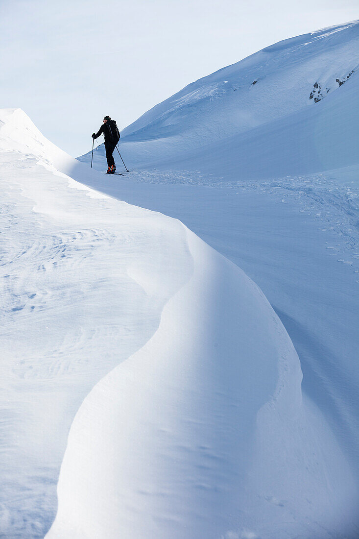 Backcountry skier ascending Sonntagskogel peak, Tennengebirge mountains, Salzburg, Austria