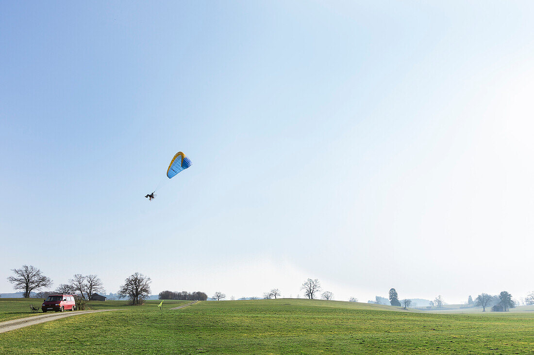 Motor-Gleitschirm startet von Wiese, Penzberg, Oberbayern, Deutschland