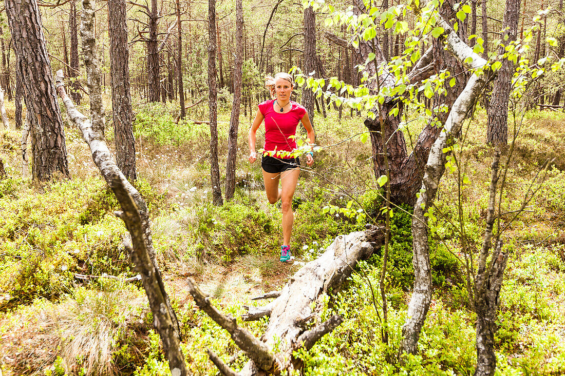 young woman running in a moorland forest, Berg at Lake Starnberg, Upper Bavaria, Germany