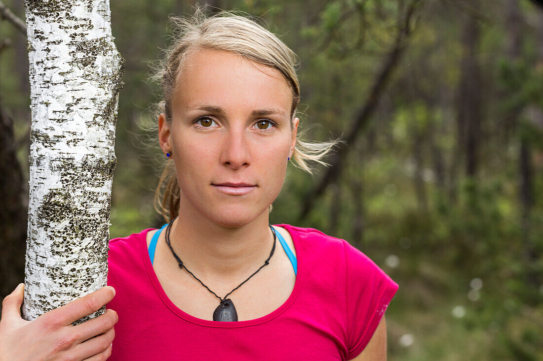 young woman near a birch tree in a moorland forest, Berg at Lake Starnberg, Upper Bavaria, Germany