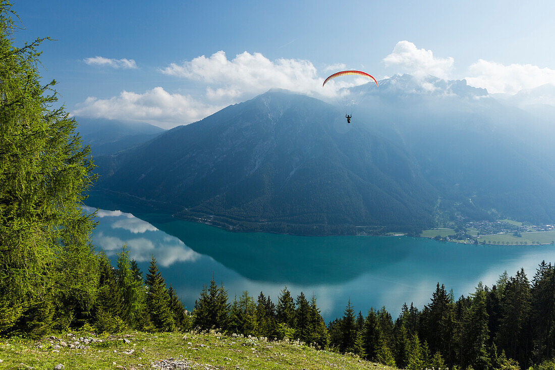 Paraglider starting off from Zwoelferkopf above Lake Achensee, overlooking Rofan mountains, Pertisau, Tirol, Austria