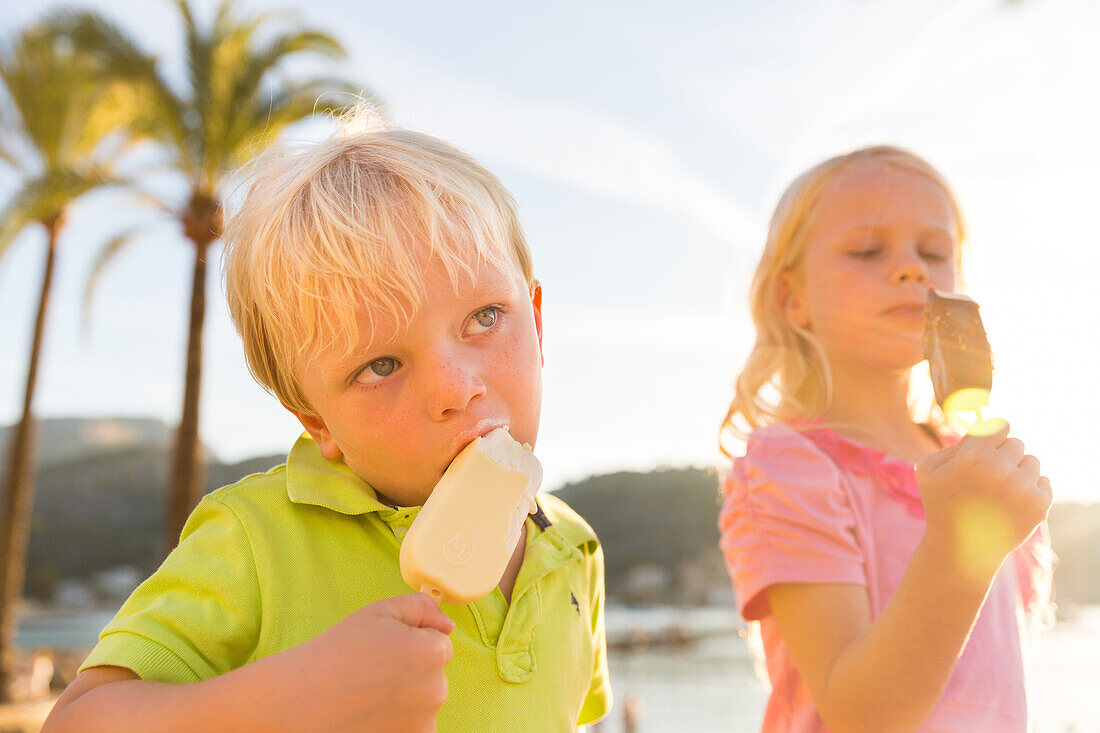 4 and 5 year old boy and girl eating, ice cream in the harbour, MR, Port de Soller, Serra de Tramuntana, Majorca, Balearic Islands, Spain, Europe