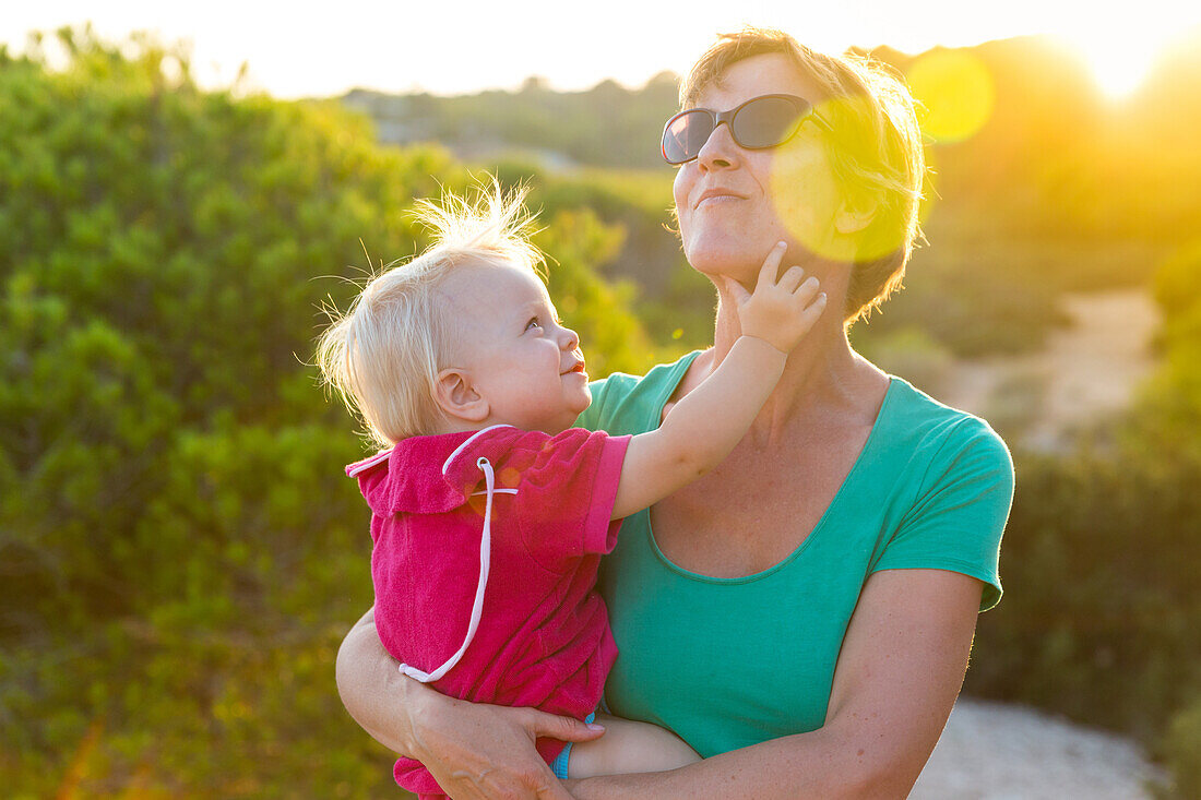 Mother with small child, girl, 1 year old, in the evening sun, summer, Calo des Moro, Mediterranean Sea, MR, near Santanyi, Majorca, Balearic Islands, Spain, Europe