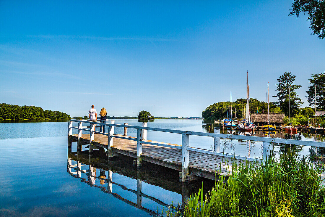 Couple on a pier at lake Ploen, Bosau, Holstein Switzerland, Ostholstein, Schleswig-Holstein, Germany