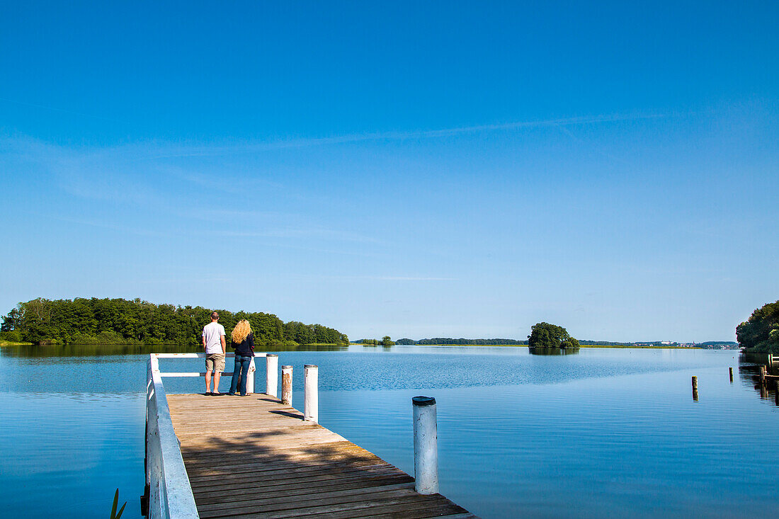 Couple on a pier at lake Ploen, Bosau, Holstein Switzerland, Ostholstein, Schleswig-Holstein, Germany