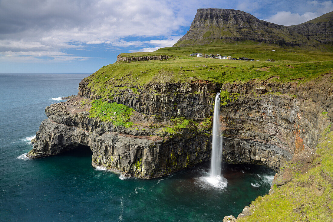 Waterfall flowing directly into the sea at Gasadalur, Vagar Island, Faroe Islands