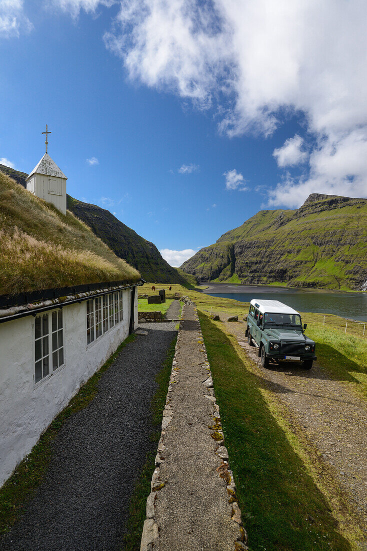 Kirche und See in Saksun mit Land Rover Defender, Insel Streymoy, Färöer Inseln (Føroyar)