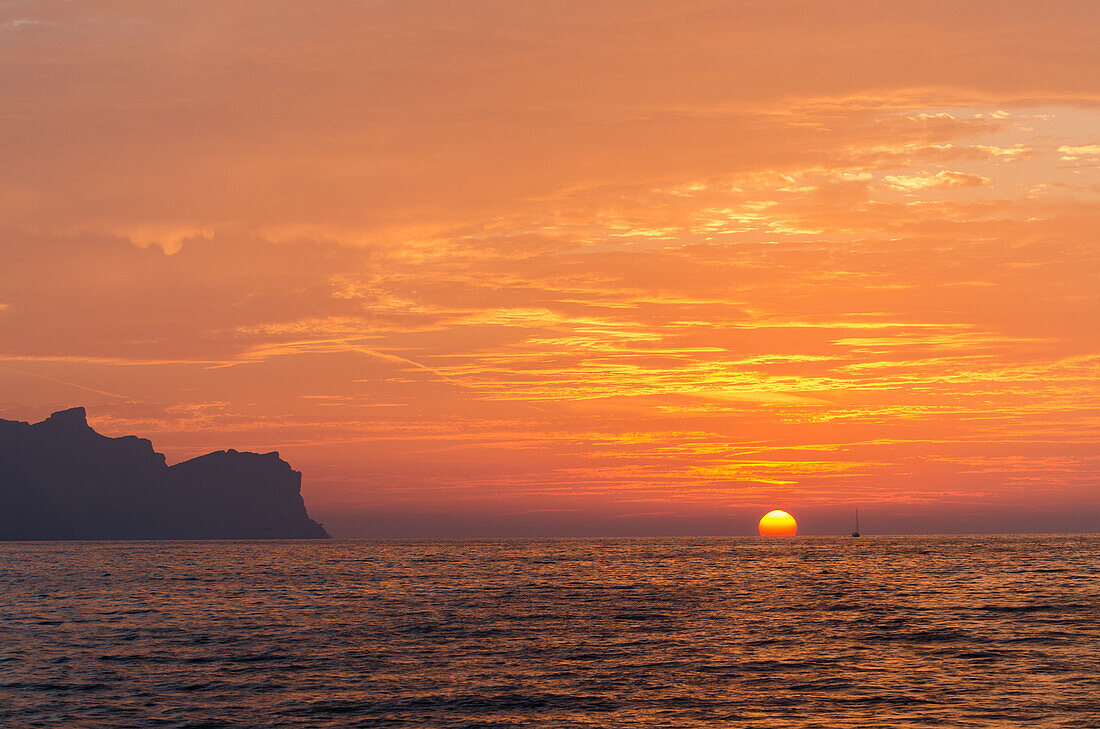 Eine Segelyacht im Sonnenuntergang an der Nordküste von Mallorca, Balearen, Spanien, Europa