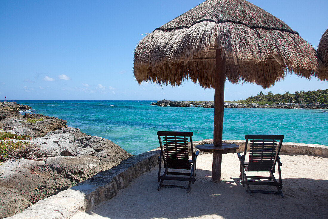 Thatched umbrella and lounge chairs at Xel-Ha Water Park, Tulum, Riviera Maya, Quintana Roo, Mexico