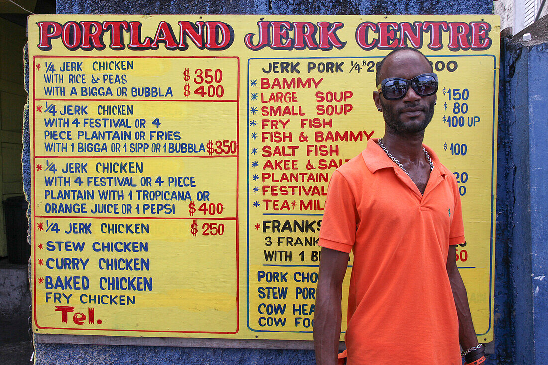 Man in front of Portland Jerk Center sign, Port Antonio, Portland, Jamaica