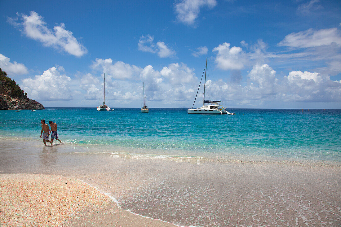 Junges Paar am Strand Governor's Beach mit Segelbooten, Gustavia, St. Barthelemy (St. Barth), Karibik