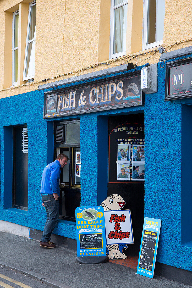 Mann geht in Fish & Chips Laden, Portree, Isle of Skye, Highland, Innere Hebriden, Schottland, Großbritannien, Europa