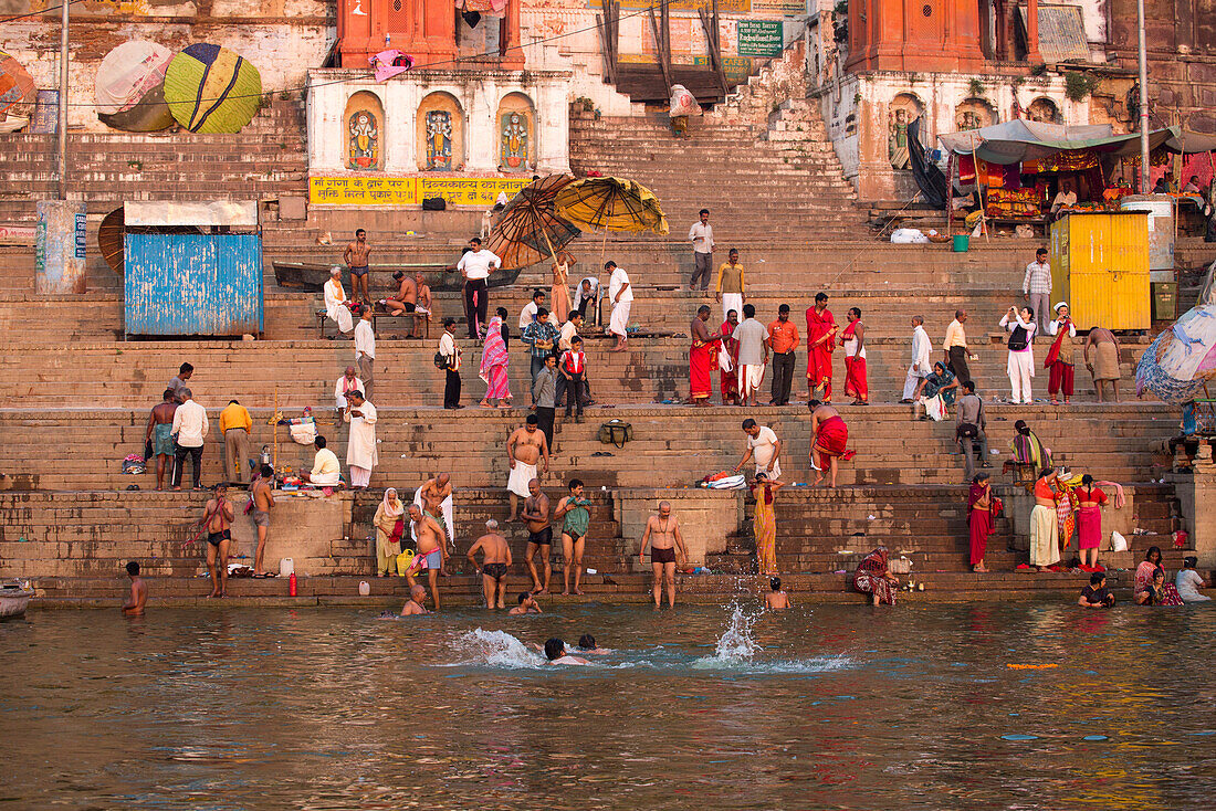 Menschen waschen sich und beten am Dasaswamedh Ghat am Ufer des Fluss Ganges, Varanasi, Uttar Pradesh, Indien