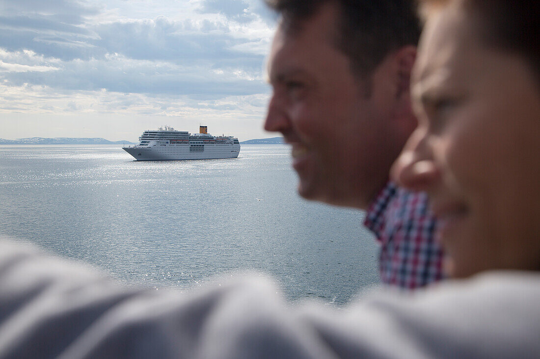 Couple at railing of cruise ship with cruise ship Costa Neo Romantica (Costa Crociere) in distance, Honningsvåg, Magerøy, Finnmark, Norway