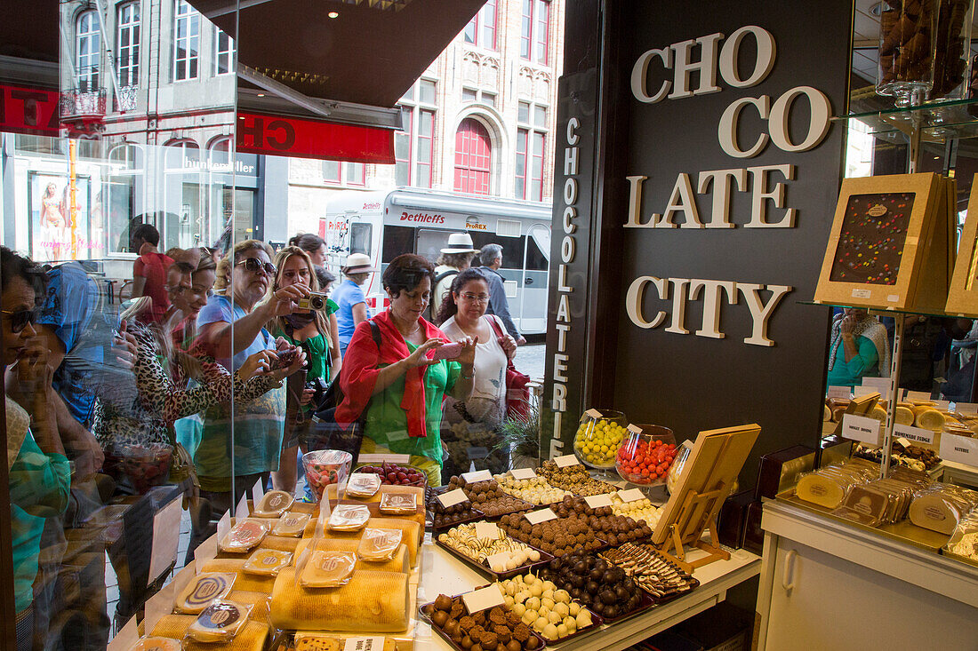 Menschen blicken auf Auslagen mit belgischen Pralinen und Schokolade im Chocolate City Süßwarengeschäft, Brügge, Flandern, Belgien, Europa
