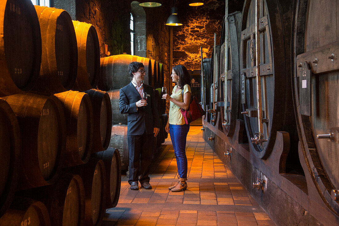 Mann und Frau genießen Portwein während einer Weinprobe im Keller des Weinguts Burmester, Porto, Norte, Portugal, Europa