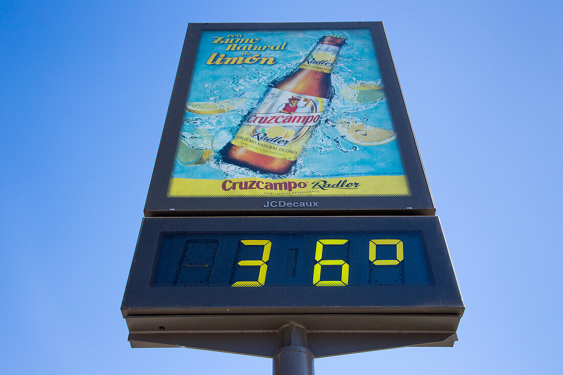 36 degrees celsius on temperature sign with beer advertisement, Seville, Andalusia, Spain