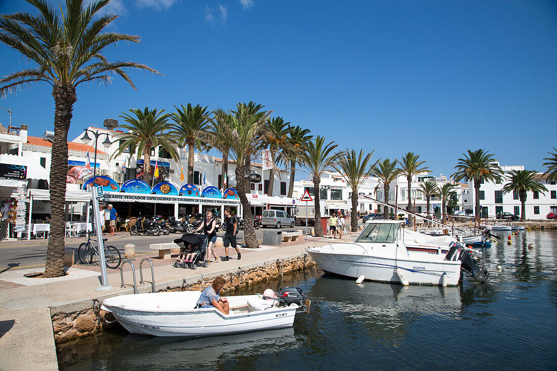 Fischerboote im Hafen mit Bars und Restaurants an der Hafenpromenade, Fornells, Menorca, Balearen, Spanien, Europa