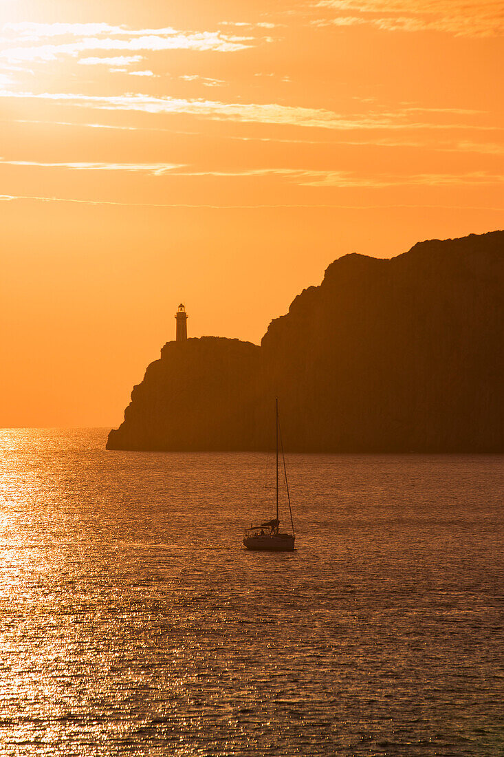 Silhouette of sailboat and Faro di Capri lighthouse at sunset, Isola di Capri, Campania, Italy