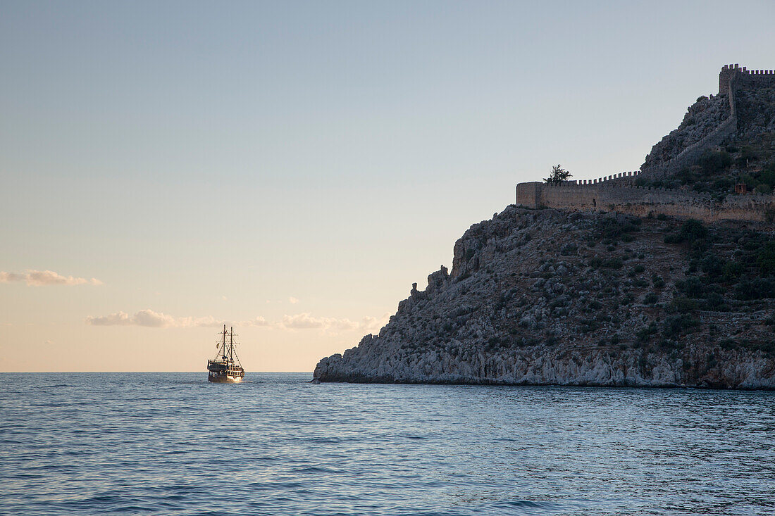 Ausflugsboot und Festungsmauer bei Sonnenuntergang, Alanya, Antalya, Türkei, Europa