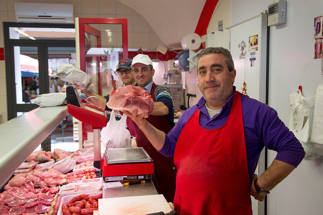 Proud butchers with meat at butcher shop, Crotone, Calabria, Italy