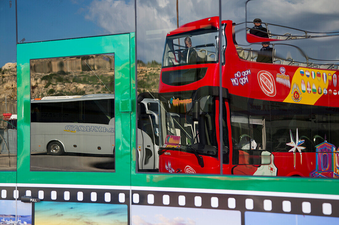 Spiegelung eines Hop on Hop off City Sightseeing Gozo Bus in einem Fenster von einem Reisebus, Mgarr, Gozo, Malta, Europa