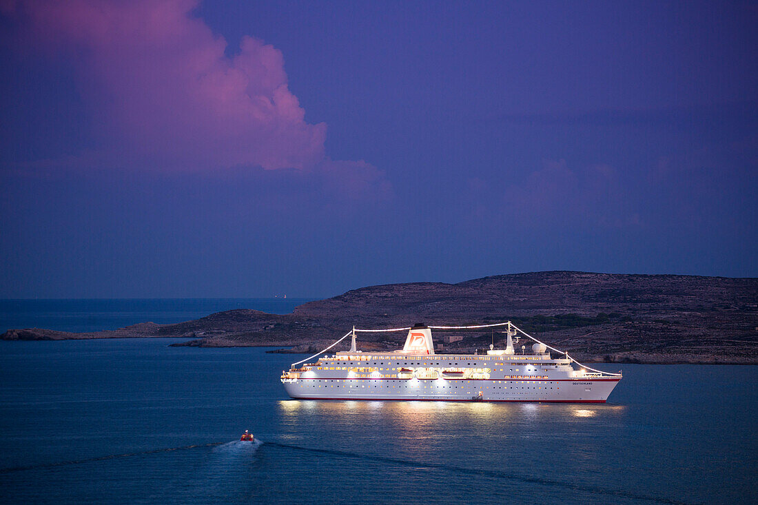 Kreuzfahrtschiff MS Deutschland (Reederei Peter Deilmann) mit Insel Camino in der Abenddämmerung, Mgarr, Gozo, Malta, Europa
