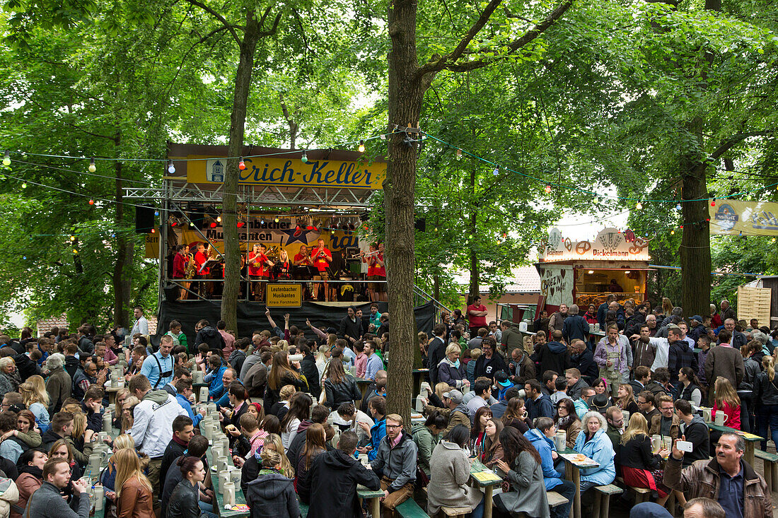 People sit outside in beer garden and enjoy live music at the Erlanger Bergkirchweih beer festival and fair, Erlangen, Franconia, Bavaria, Germany