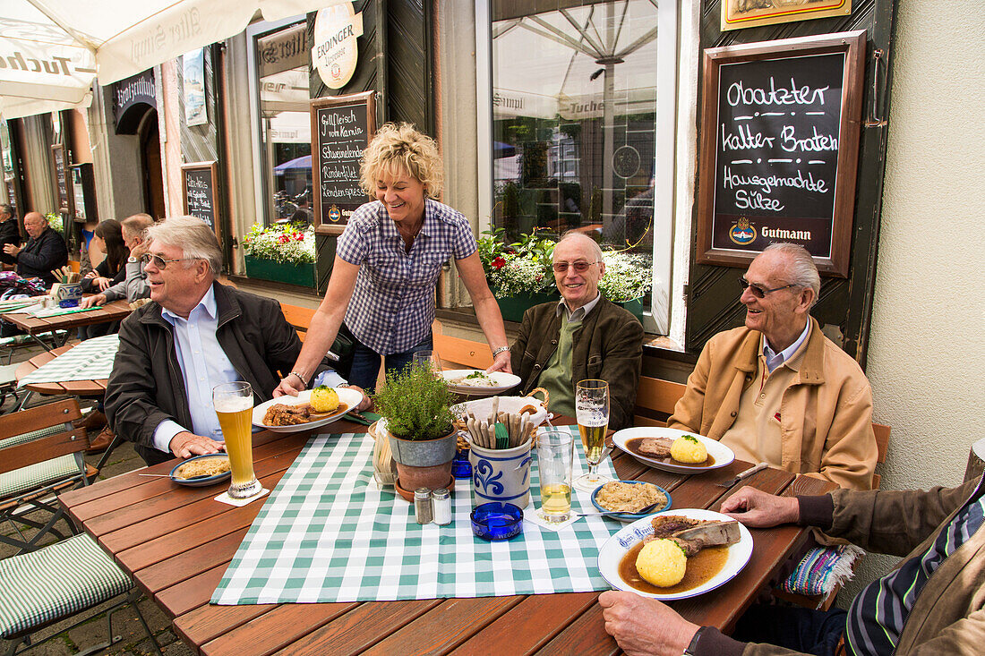 Fröhliche Wirtin serviert köstliche Schäufele im Alter Simpl Gasthaus mit Biergarten, Erlangen, Franken, Bayern, Deutschland, Europa