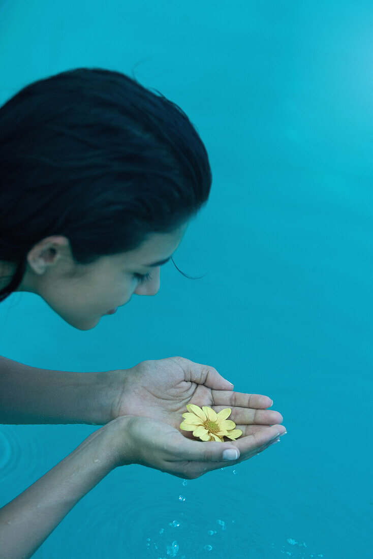 Woman holding flower cupped in hands