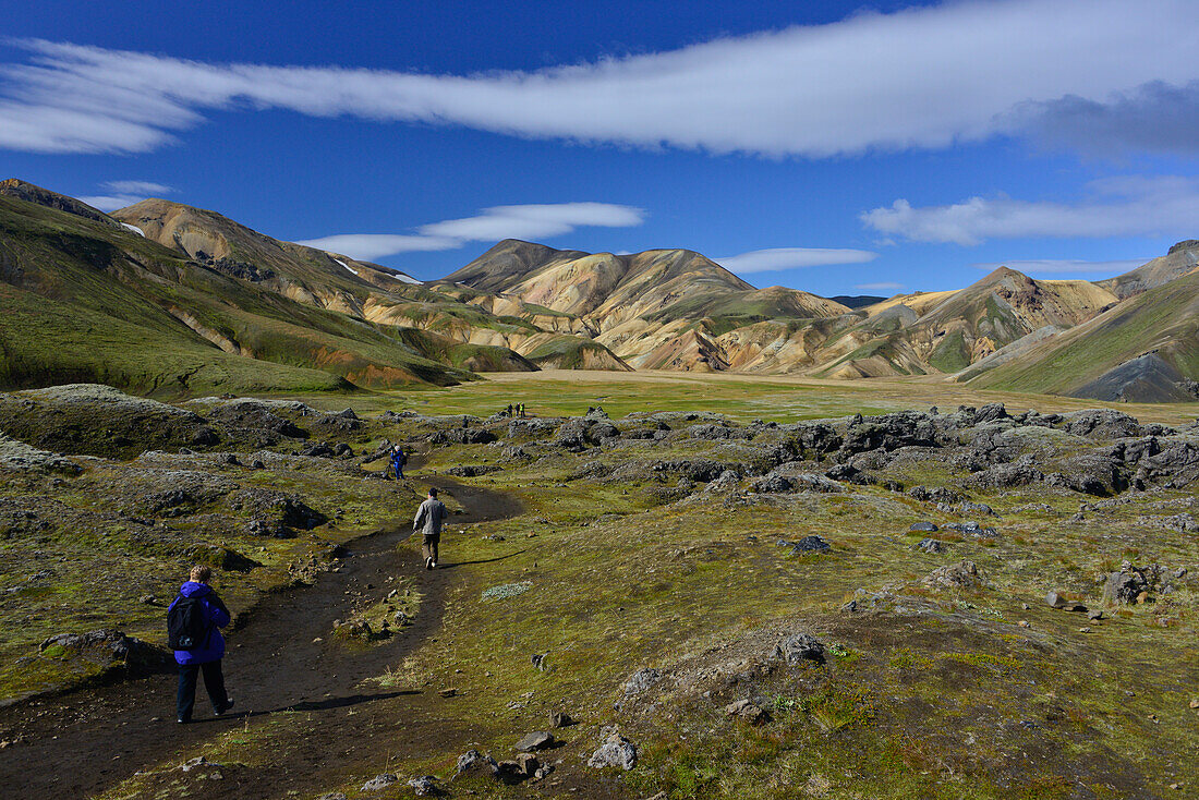 Wanderer auf dem Trekking Weg Laugavegur vorbei an farbigen Bergen und Lavafeldern, Landmannalaugar, Hochland, Südisland, Island, Europa