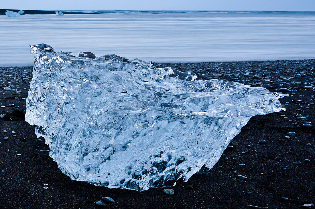 Blue Icebergs and drift ice at black lava beach from glacier lake Jokulsarlon at Vatnajökull near Skaftafell National Park, East Iceland, Iceland, Europe