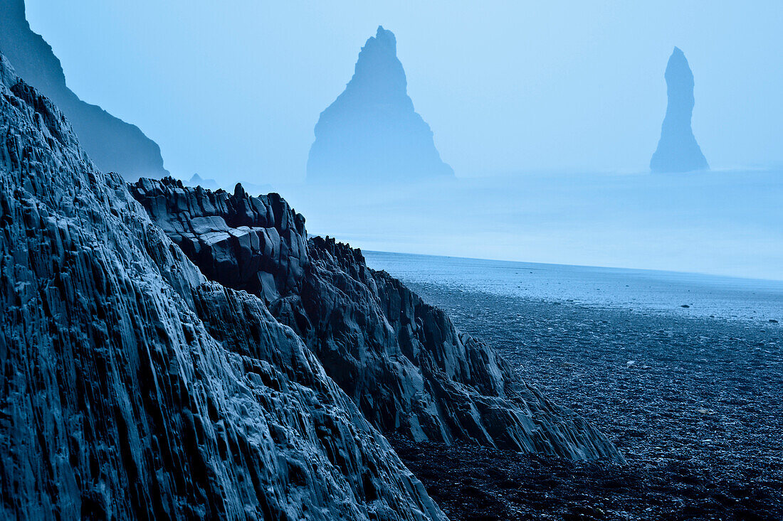 Basaltformationen Reynisdrangar  im Meer, Schwarzer Lavastrand an der Küste von Vik I Myrdal, Südisland, Island, Europa