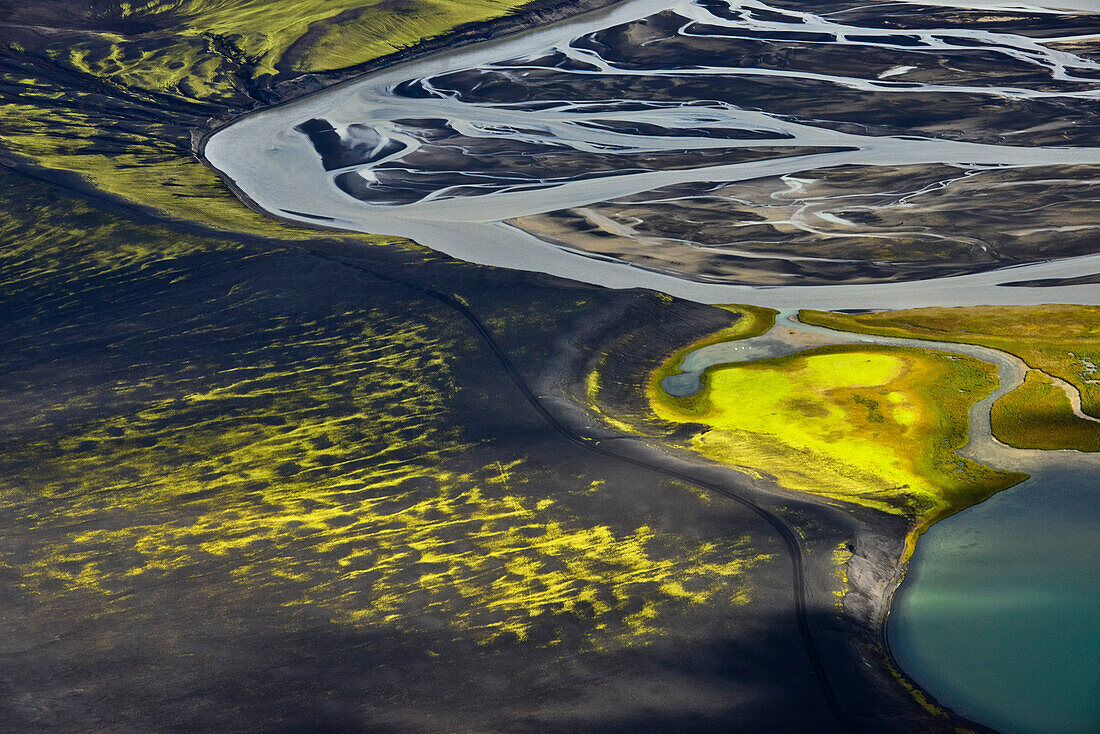 Aerial view of meander of  glacial river tungnaa floating over a sander area covered with fluorescent moss, Veidvotn, Highlands, South Iceland, Iceland, Europe