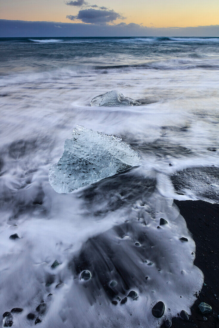 Ice blocks at sunset being washed up from glacial lake Jokulsarlon  at Vatnajokull,  Breidamerkursandur between Skaftafell National Park und Hofn, East Iceland, Iceland, Europe
