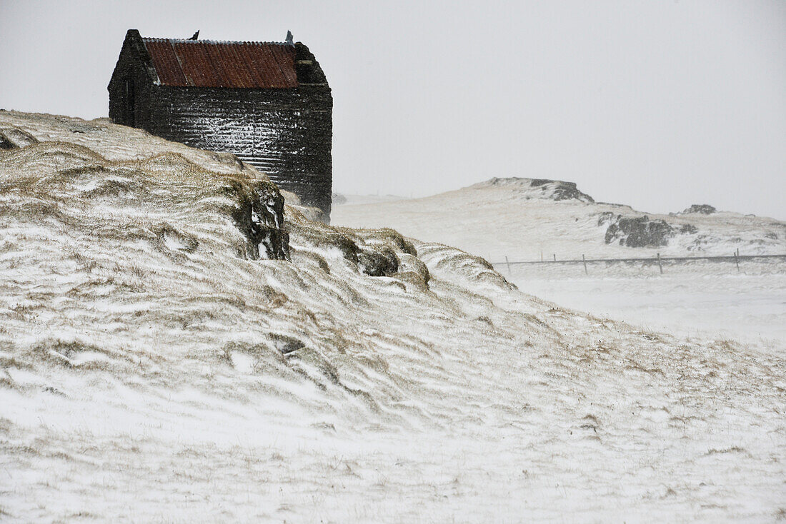 Verlassenes Bauernhof in verschneiter Landschaft bei Höfn, Ostisland, Island, Europa