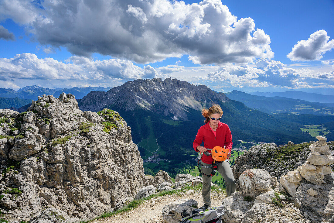 Woman putting on climbing helmet, fixed rope route Masare, Masare, Rotwand, Rosengarten, UNESCO world heritage Dolomites, Dolomites, Trentino, Italy