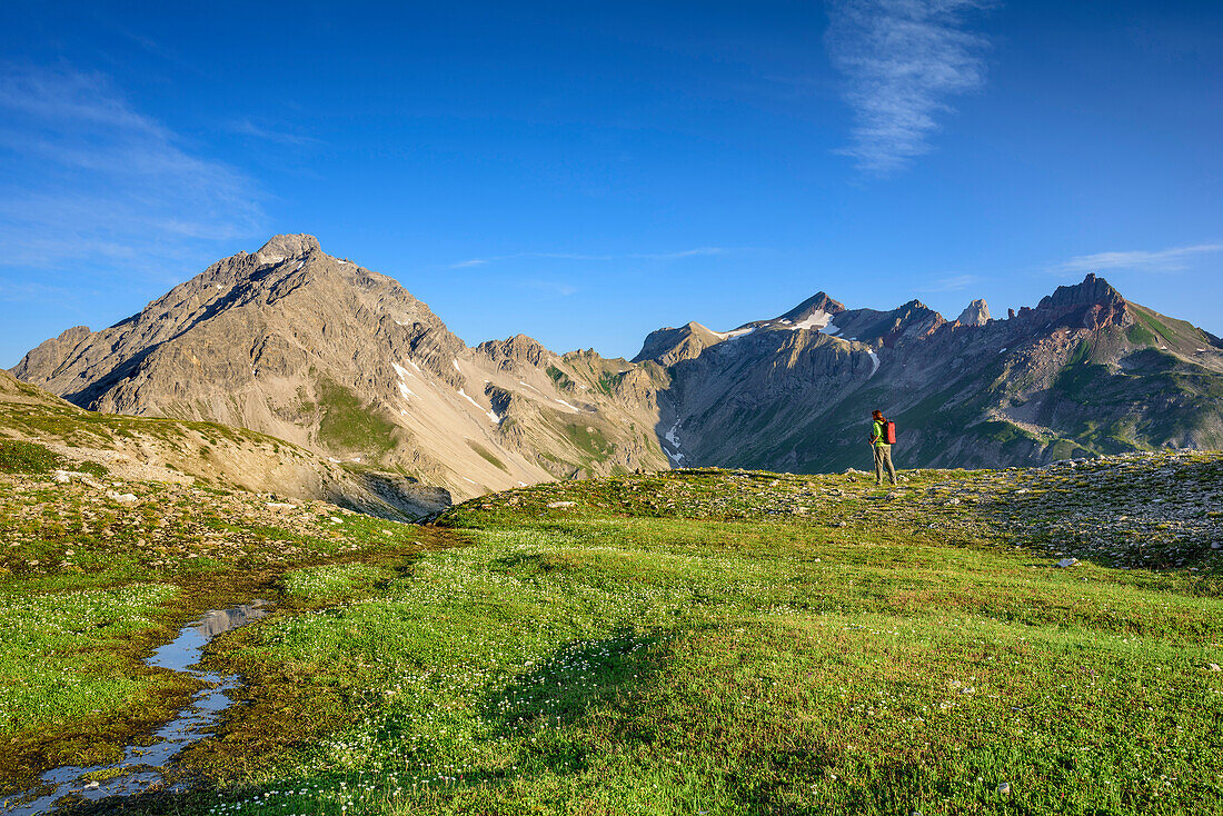 Woman hiking with Vorderseespitze and Feuerspitze in background, Lechtal Alps, Tyrol, Austria