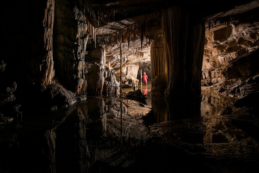 Hiker exploring stalactites in cave, Loz, Notranjska, Slovenia