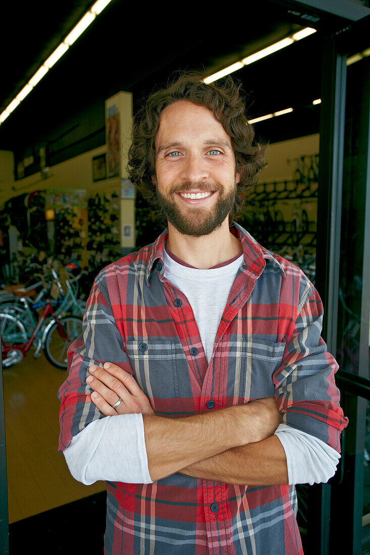 Caucasian man smiling in bicycle shop, Los Angeles, California, USA