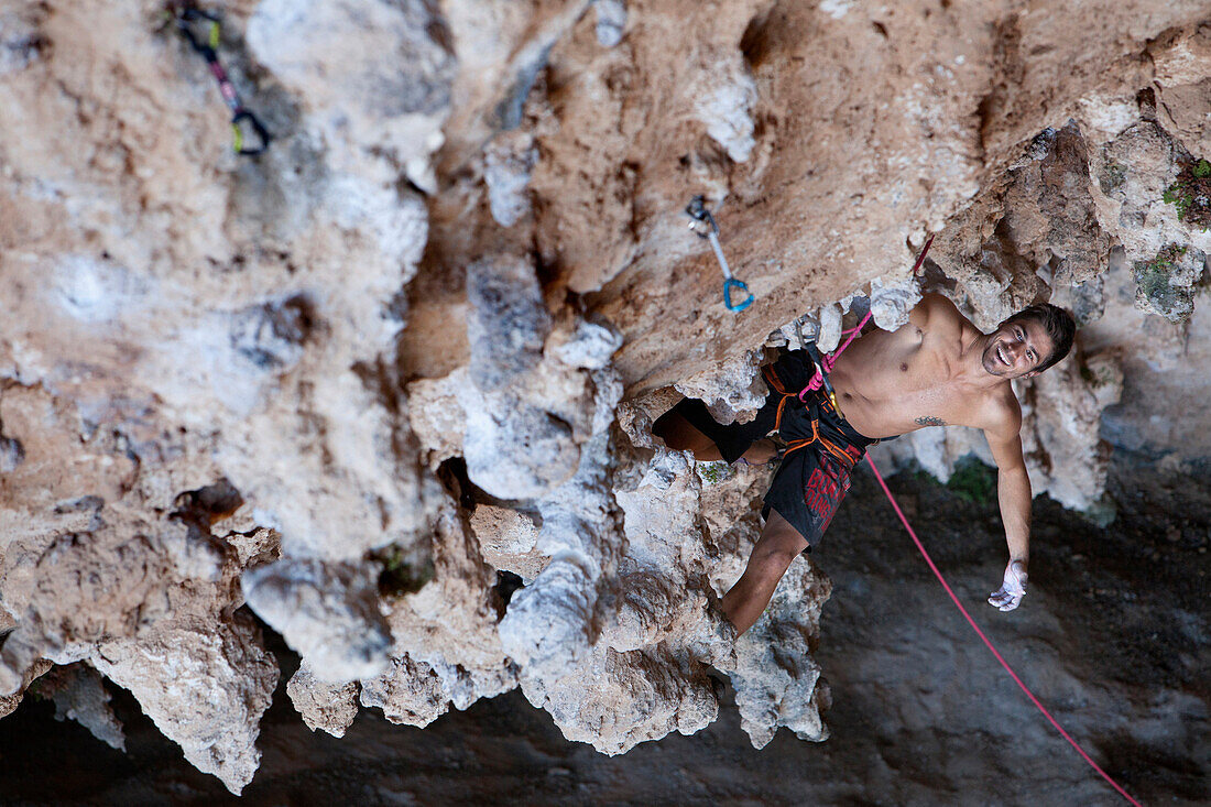 Climber smiling on rocky cave ceiling, Kalymnos, Dodecanese , Greece