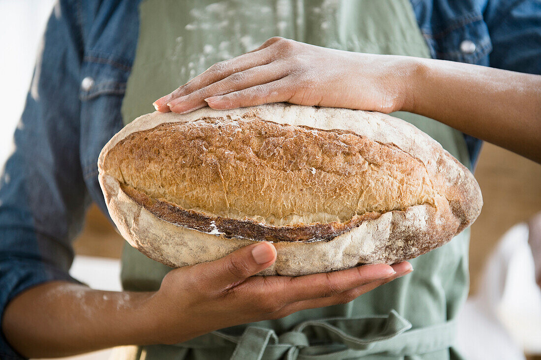 Mixed race woman holding loaf of bread, Jersey City, New Jersey, USA