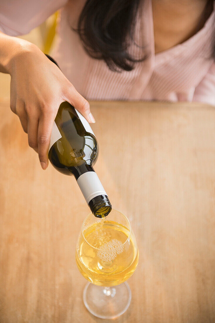 Mixed race woman pouring glass of wine, Jersey City, New Jersey, USA