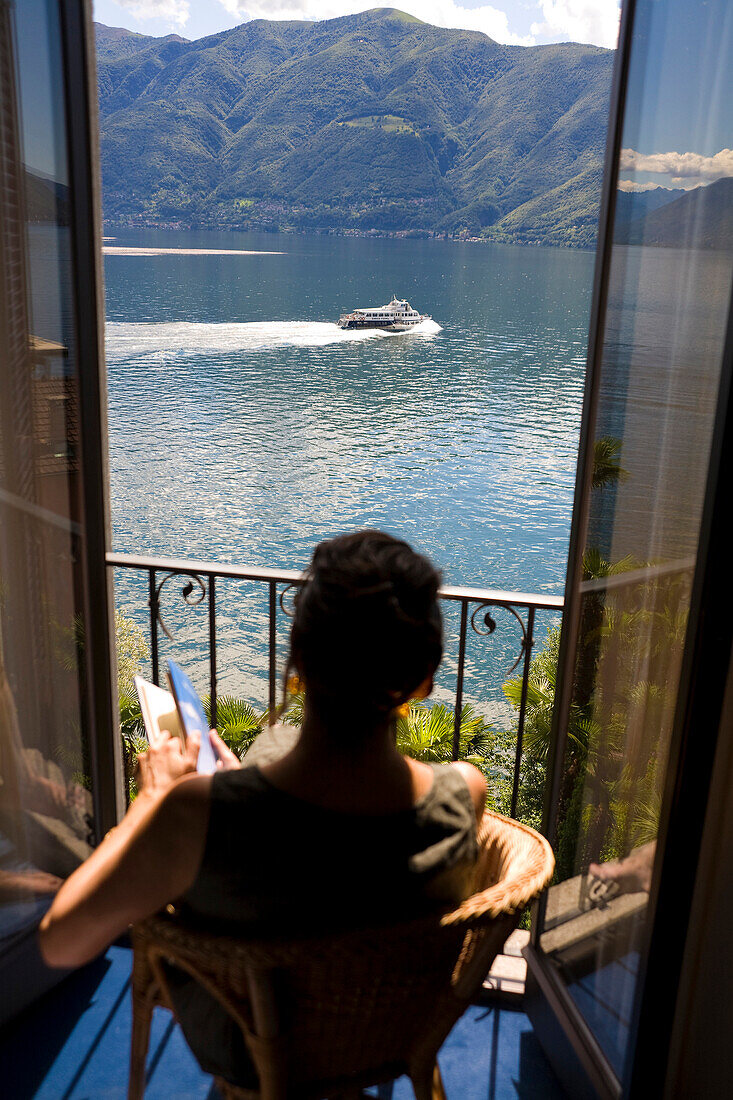 Woman overlooking rural lake from balcony, Lugano, Ticino, Switzerland, Lugano, Ticino, Switzerland