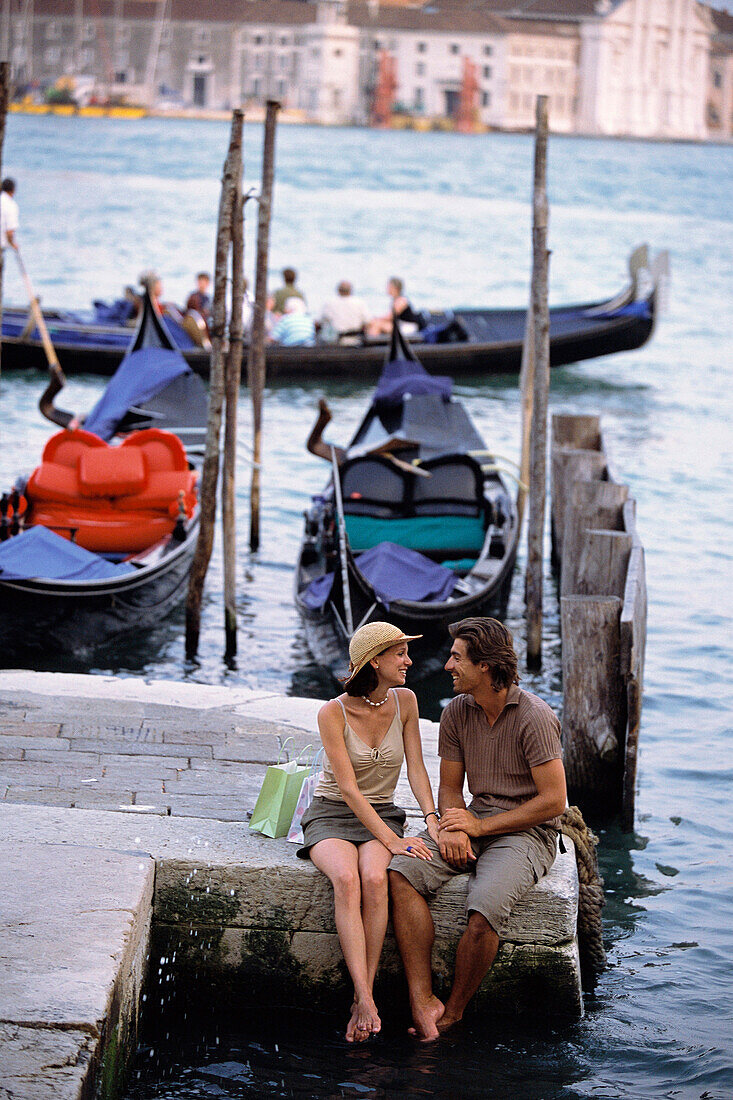 Caucasian sitting together by canal, Venice, Veneto, Italy, Venice, Veneto, Italy