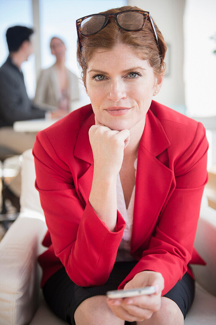 Businesswoman using cell phone in office, Jersey City, New Jersey, USA